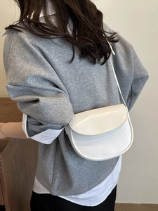 Elegant ivory minimalist saddle bag with smooth finish and adjustable shoulder strap