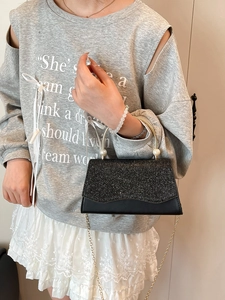 Sac à main noir à paillettes avec poignée en métal doré et accents de perles