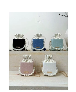 Detail of mini drawstring bucket bags in five colors with pearl handles and gold chains