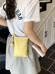 Secchiello chic in pelle gialla con tracolla a nodi indossato da una modella