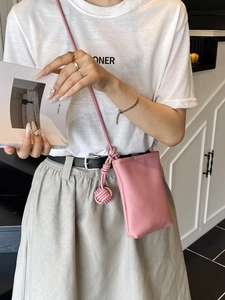 Borsa a secchiello in pelle rosa con tracolla a nodo per uno stile estivo minimalista