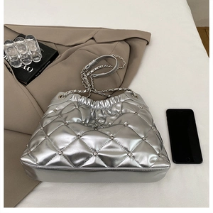Detail of silver quilted chain bag featuring sparkling rhinestones and metallic finish