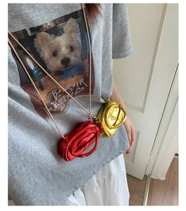 Close-up of mini metallic crossbody bags in red and gold with slim chain straps