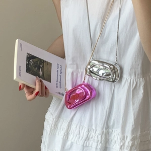 Detailed close-up of metallic fluid-wave mini chain bag in silver and rose pink