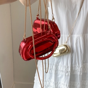 Close-up of mini 3D oval handbags with shiny metallic finish and gold chains