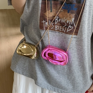 Detail of metallic chain bags in gold and pink featuring stylish overlapping ring designs
