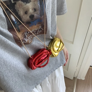 Detail of mini metallic crossbody bag with mirror finish and elegant gold chain strap