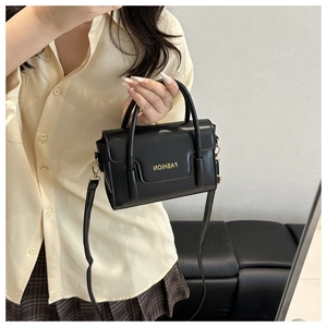 Vue détaillée du mini sac à main noir avec lettrage doré et bandoulière amovible