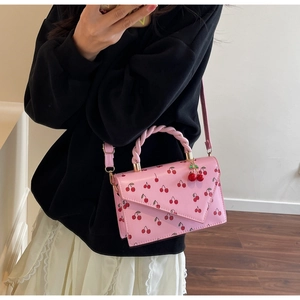 Sac à bandoulière rose avec motif cerise et breloque cerise 3D en décor lifestyle
