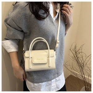 Détail du mini sac bandoulière beige minimaliste avec logo doré et bandoulière réglable