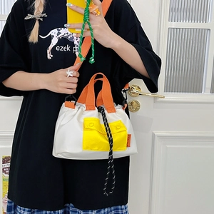 Detail of color-block nylon tote bag with orange straps and drawstring closure