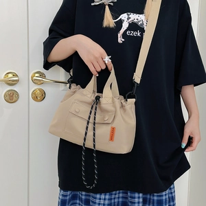 Khaki nylon tote bag with drawstring closure and crossbody strap in a minimalist style