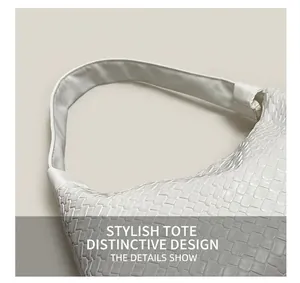 Close-up of the intricate white woven leather texture and wide strap on the shoulder bag