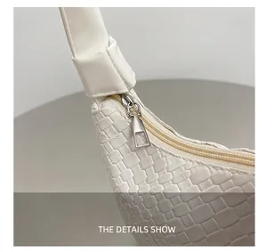 Detail of white woven leather tote featuring a smooth silver metal geometric zipper