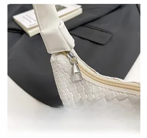 Detail of white woven leather tote featuring a smooth silver metal geometric zipper