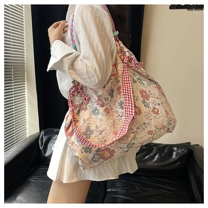 Detail of floral tote bag with large capacity and red checkered crossbody strap