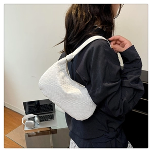 Detailed view of white woven hobo bag showing texture and trendy crescent shape