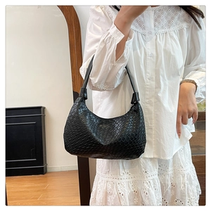 Close-up of black woven leather texture on a stylish hobo shoulder bag for women