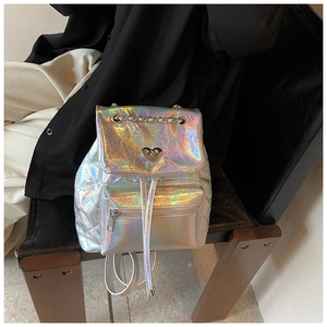 Detail of silver holographic backpack featuring heart turn-lock and quilted texture