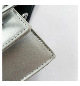 Close-up of silver leather texture and precision stitching on this fashion mini bag