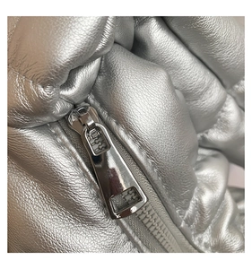 Detail of silver metallic textured faux leather with a heavy-duty chrome zipper head