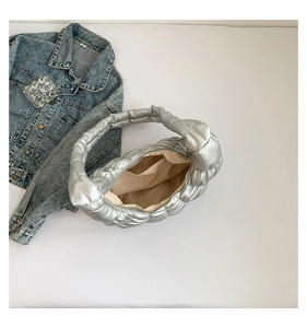 Top view of silver pleated cloud bag showing beige lining and interior zipper detail