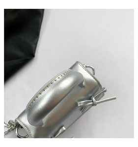 Detailed close-up of metallic silver mini bag featuring iconic side knot and handle