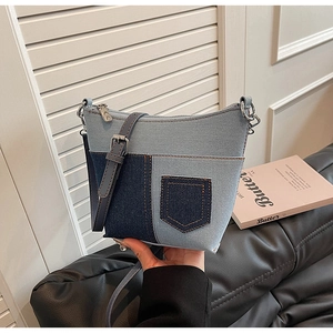Detail der blauen Denim-Patchwork-Beuteltasche mit Kontrastpaneelen und Lederriemen