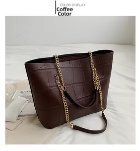 Close-up of brown crocodile texture PU leather tote with elegant gold chain strap