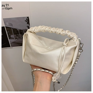 Détail du sac blanc crème avec poignée froncée et bandoulière en chaîne argentée