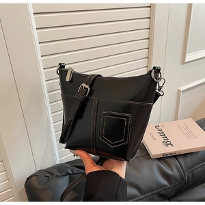 Details einer schwarzen Beuteltasche mit braunen Kontrastnähten und Silberbeschlägen
