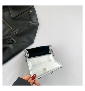 Detail view of silver mini crossbody bag with magnetic clasp and delicate chain strap
