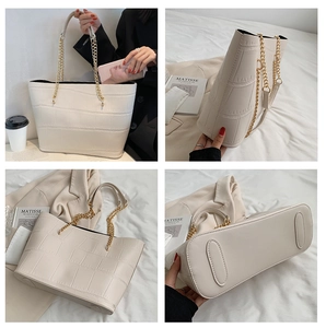 Detailed views of white crocodile pattern tote bag with gold chain strap and metal feet
