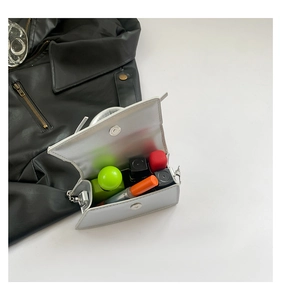 Top view of silver metallic mini bag showing interior space with lipstick and perfume