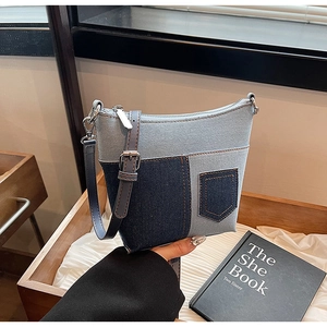 Detail der Denim-Patchwork-Achseltasche mit Kontrastnähten und verstellbarem Lederriemen