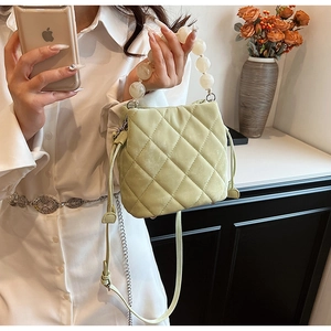 Détail du sac seau matelassé vert clair avec poignée en perles et fermeture à cordon