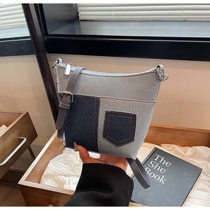 Detailaufnahme der Patchwork-Jeans-Beuteltasche mit silbernem Reißverschluss und Gurt