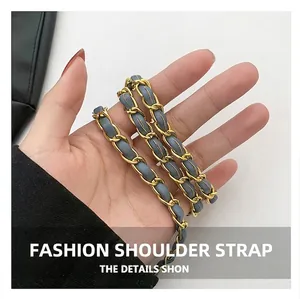Détail de la bandoulière en chaîne dorée et cuir bleu pour petit sac cylindrique