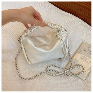 Détail du sac à main blanc crème avec poignée plissée en satin et chaîne argent