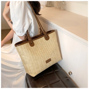 Macro shot of vertical woven paper rope texture and leather trim on minimalist tote bag