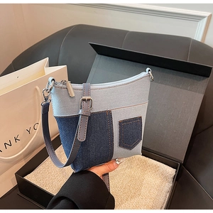 Detailaufnahme der Patchwork-Jeans-Beuteltasche mit Reißverschlüssen und Riemen