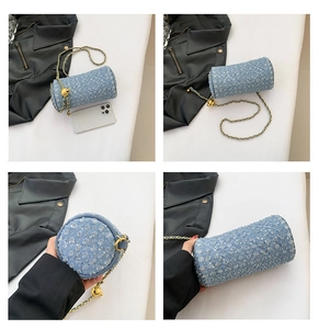 Détails de la texture denim à paillettes bleu clair et de la chaîne dorée du sac cylindre