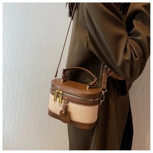 Détails des coutures en cuir marron et toile beige avec double fermeture éclair métal