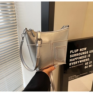 Detailansicht der silbernen Metallic-Schultertasche mit Ziernähten und polierten Beschlägen