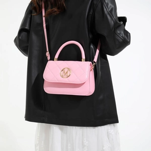 Pink quilted leather crossbody bag with gold M logo shown on a model for scale and style