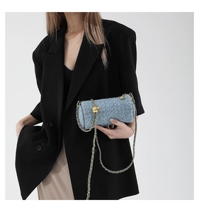 Détail du sac cylindre en jean bleu à fleurs avec chaîne à bille dorée ajustable