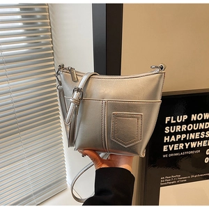 Detail der silbernen Metallic-Schultertasche mit Vordertasche und verstellbarem Gurt