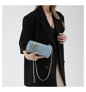 Détail du sac cylindre en tweed bleu clair à paillettes avec chaîne dorée