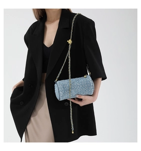 Détail du sac cylindre en tweed bleu clair avec chaîne dorée et texture pailletée