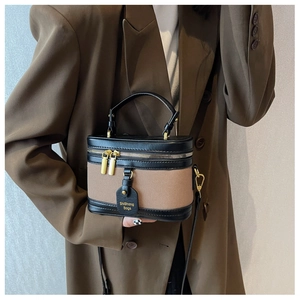 Détail du mini sac seau vintage en toile et cuir noir avec fermetures éclair dorées